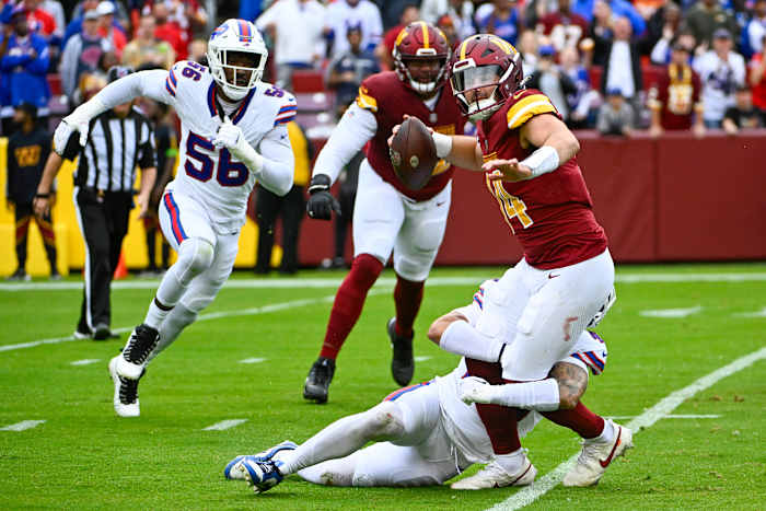 Commanders quarterback Sam Howell attempts to throw a pass while being tackled against the Bills.